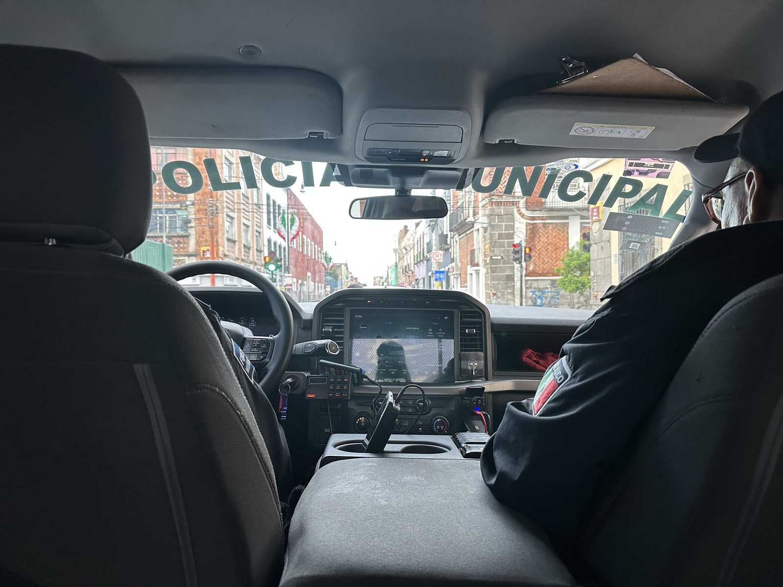Patrulla de la policía municipal recorriendo el tianguis de Puebla, vista desde el interior del vehículo
